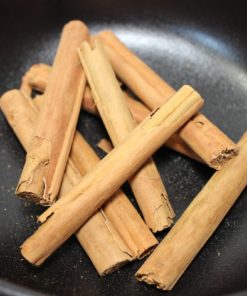 Bâtons de cannelle dans une poêle, parfaits pour infuser saveur et arôme aux plats et boissons chaudes.