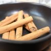 Bâtons de cannelle dans un bol noir : épice aromatique pour cuisiner ou infuser des boissons.
