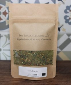 Paquet de curry oriental biologique Les épices curieuses sur un fond à motifs colorés.