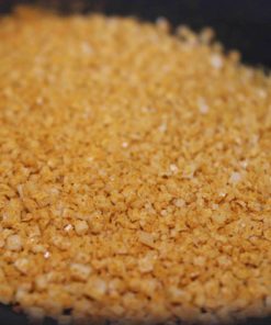Granules dorés de sel aromatisé, gros plan. Utilisé pour rehausser les saveurs culinaires.