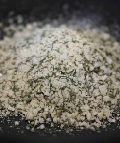 Sel aromatisé aux herbes sur fond noir, idéal pour rehausser la saveur des plats.