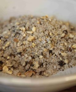 Mélange aromatique de poivre noir et d'écorces séchées dans un bol blanc.