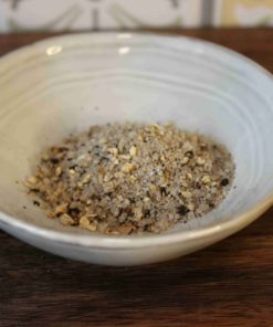 Assortiment de sel épicé dans un bol en céramique, idéal pour rehausser les saveurs de vos plats.