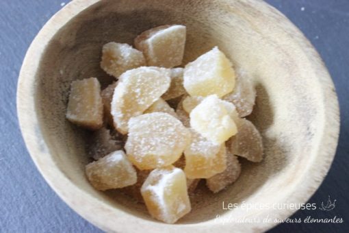 Morceaux de gingembre confit dans un bol en bois, délice sucré et épicé idéal pour agrémenter vos recettes exotiques.