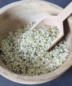 Bol en bois rempli de graines de chanvre biologiques avec cuillère en bois. Source de protéines et d'oméga-3.
