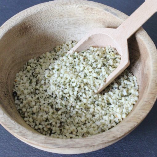 Bol en bois rempli de graines de chanvre biologiques avec cuillère en bois. Source de protéines et d'oméga-3.