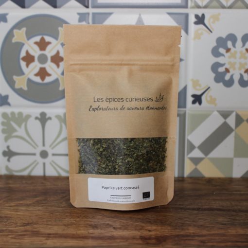 Sachet de paprika vert concassé par Les épices curieuses, sur fond de carrelage décoratif.