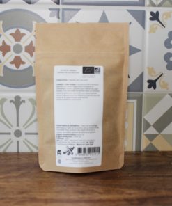 Sachet d'épices bio sur fond de carrelage coloré, idéal pour sublimer vos plats avec des saveurs authentiques.
