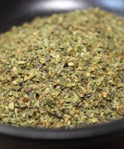 Herbes sèches dans un bol noir, idéales pour assaisonner vos plats et rehausser les saveurs de la cuisine méditerranéenne.