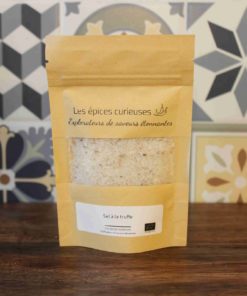 Paquet de sel à la truffe Les épices curieuses devant un fond de carreaux décoratifs.