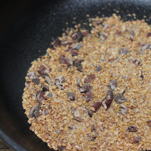 Gros sel et assaisonnements variés dans un bol noir prêts pour la cuisine.