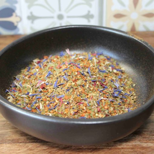 Mélange d'épices coloré dans un bol noir sur fond de carrelage marocain, idéal pour relever vos plats.