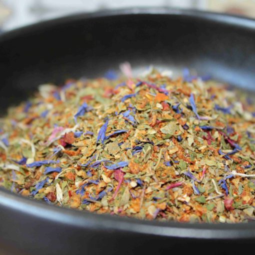 Mélange d'épices colorées dans un bol noir, parfait pour rehausser la saveur des plats.