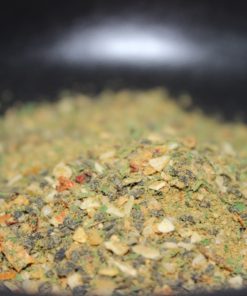 Mélange d'épices colorées avec morceaux secs d'herbes et de légumes, idéal pour assaisonner plats variés et intensifier saveurs.