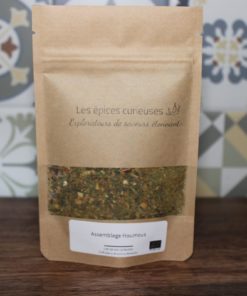 Mélange d'épices houmous par Les Épices Curieuses dans un sachet kraft, devant un fond décoratif.