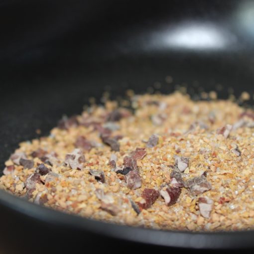 Mélange de grains et de graines dans un récipient noir, utilisé pour la cuisine ou la décoration.