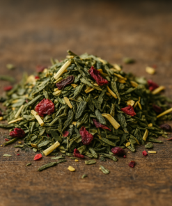Mélange de thé vert avec baies rouges et herbes séchées sur une table en bois.