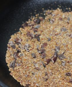 Gros sel et assaisonnements variés dans un bol noir prêts pour la cuisine.