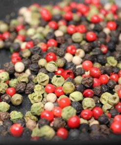 Mélange coloré de grains de poivre: rouge, noir, vert et blanc pour une cuisine épicée et aromatique.