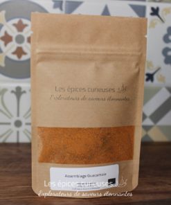 Mélange d'épices Assemblage Guacamole par Les Épices Curieuses, sur fond de carrelage coloré.