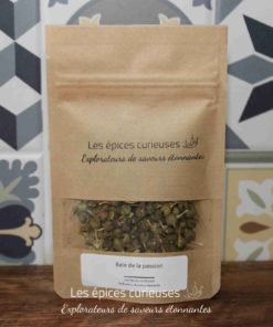 Sachet d'épices Les épices curieuses contenant des baies de la passion, fond décoratif carrelé.