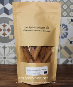 Paquet de bâtons de cannelle de Ceylan entier Les épices curieuses sur une table en bois, fond de carreaux.