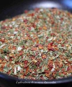 Mélange d'épices colorées dans un bol noir, parfait pour rehausser vos plats.