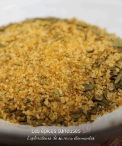 Mélange d'épices dorées sur une assiette blanche, idéal pour assaisonner vos plats.