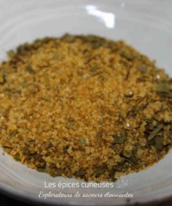 Mélange d'épices aromatiques dans un bol blanc, idéal pour assaisonner vos plats avec saveur et couleur.