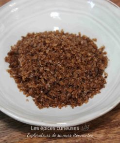 Un bol de cassonade brune sur une table en bois, idéal pour les recettes de pâtisserie.