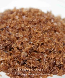Gros plan sur du sucre brun naturel en grains, texture cristalline pour pâtisserie ou cuisine raffinée.