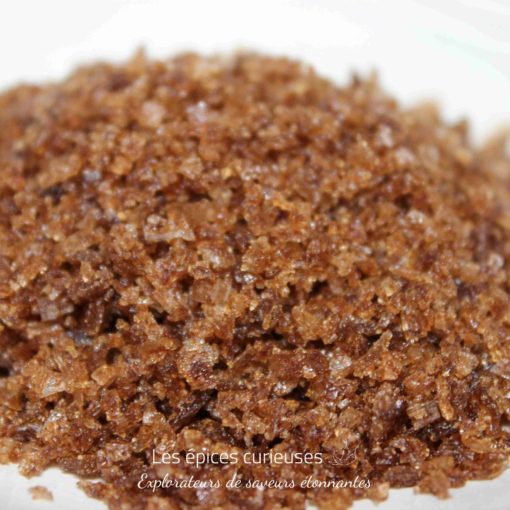 Gros plan sur du sucre brun naturel en grains, texture cristalline pour pâtisserie ou cuisine raffinée.
