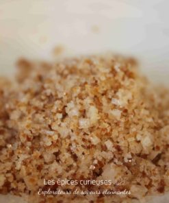 Gros plan de sucre roux naturel brillant sur fond clair.
