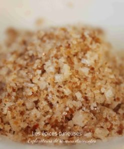Gros plan de sucre roux en cristaux, illuminant sa texture et sa couleur unique.