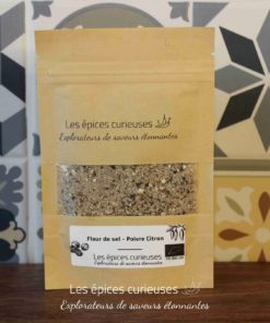 Sachet d'épices biologiques Les épices curieuses contenant fleur de sel et poivre citron, sur un fond de tuiles colorées.