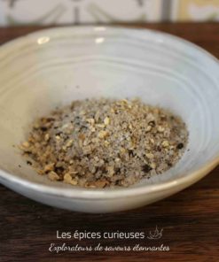 Assortiment de sel épicé dans un bol en céramique, idéal pour rehausser les saveurs de vos plats.
