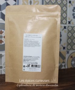 Paquet kraft d'épices Les épices curieuses avec de la poudre d'ananas, sur fond de carreaux colorés.