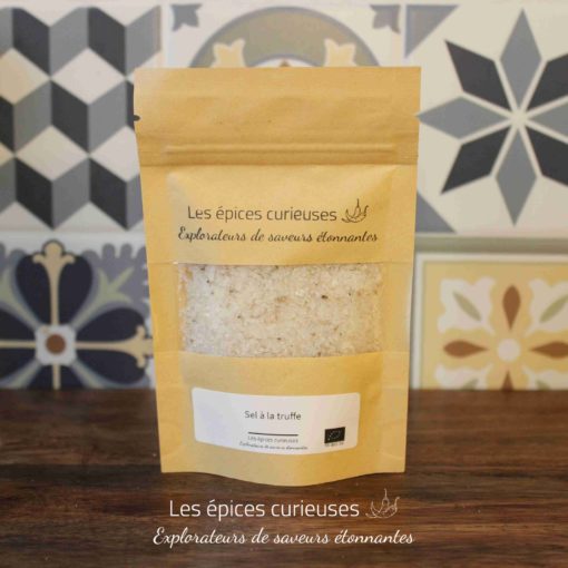 Paquet de sel à la truffe Les épices curieuses devant un fond de carreaux décoratifs.