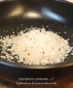 Sel de mer gourmet dans un bol noir, prêt à enrichir vos plats de sa saveur unique et délicate.
