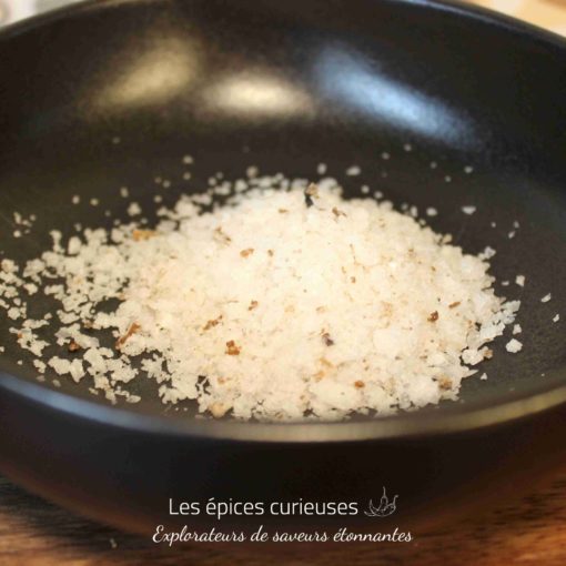 Sel de mer gourmet dans un bol noir, prêt à enrichir vos plats de sa saveur unique et délicate.