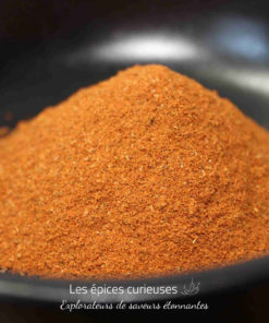 Poudre d'épices rouge vif dans un bol, idéale pour rehausser vos plats et recettes culinaires.