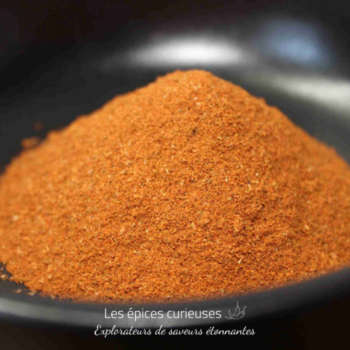 Poudre d'épices rouge vif dans un bol, idéale pour rehausser vos plats et recettes culinaires.