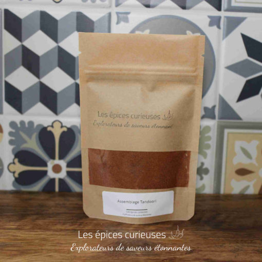 Sachet d’épices tandoori Les épices curieuses devant un carrelage décoratif.