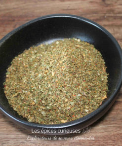 Bol de fines herbes séchées pour assaisonnement sur une table en bois. Parfait pour la cuisine méditerranéenne.