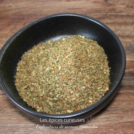 Bol de fines herbes séchées pour assaisonnement sur une table en bois. Parfait pour la cuisine méditerranéenne.