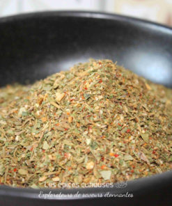 Mélange d'herbes séchées dans un bol noir, parfait pour relever les plats savoureux et ajouter une touche aromatique.