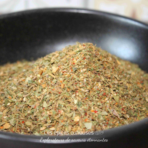 Mélange d'herbes séchées dans un bol noir, parfait pour relever les plats savoureux et ajouter une touche aromatique.