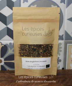 Paquet de baies de genièvre concassées de Les épices curieuses sur fond de carreaux décoratifs.