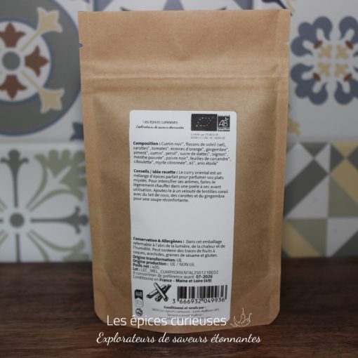 Sachet d'épices biologiques multicolores, fond fleuri. Composition variée: cumin, carottes, gingembre. Produit artisanal.