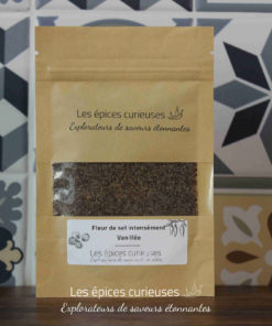 Sachet de fleur de sel vanillée Les épices curieuses devant un carrelage à motifs noirs et gris.